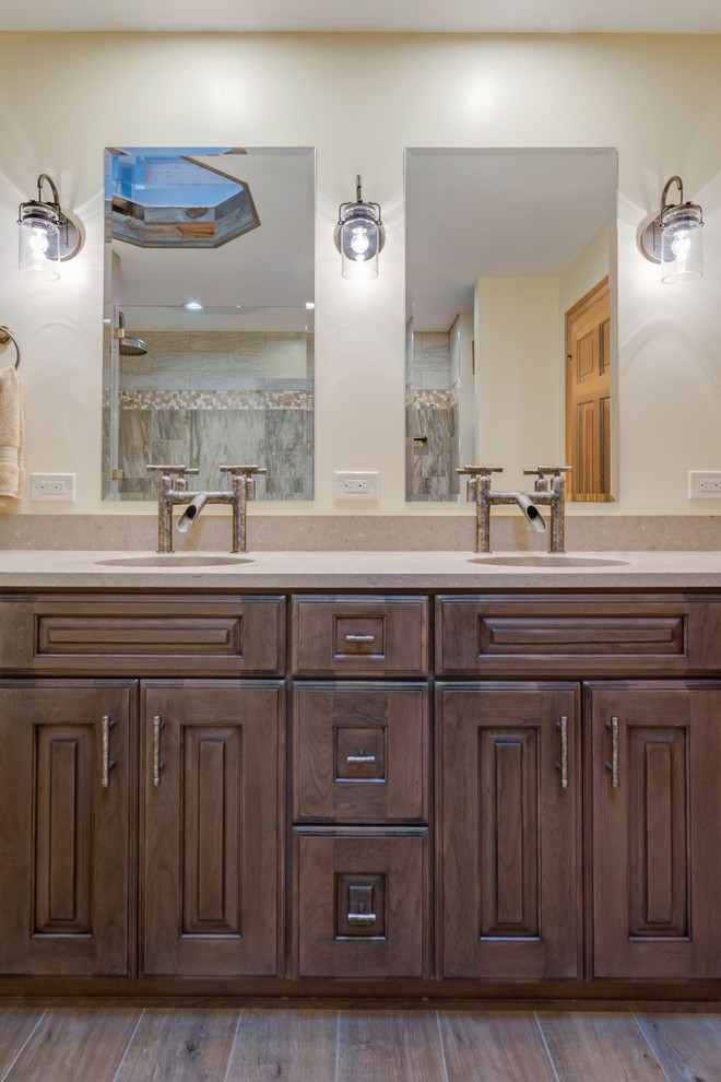 Inspiration for a large country master bathroom in Philadelphia with raised-panel cabinets, distressed cabinets, a curbless shower, a two-piece toilet, gray tile, porcelain tile, beige walls, porcelain floors, engineered quartz benchtops, brown floor, an open shower and beige benchtops.