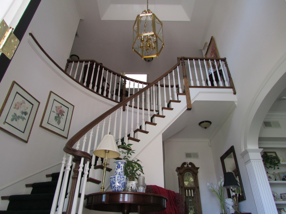 This is an example of a large traditional wood curved staircase in Los Angeles with wood risers.
