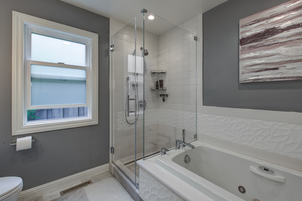 Photo of a mid-sized contemporary master bathroom in San Francisco with an undermount sink, flat-panel cabinets, white cabinets, engineered quartz benchtops, a drop-in tub, a corner shower, a one-piece toilet, white tile, porcelain tile, grey walls and marble floors.