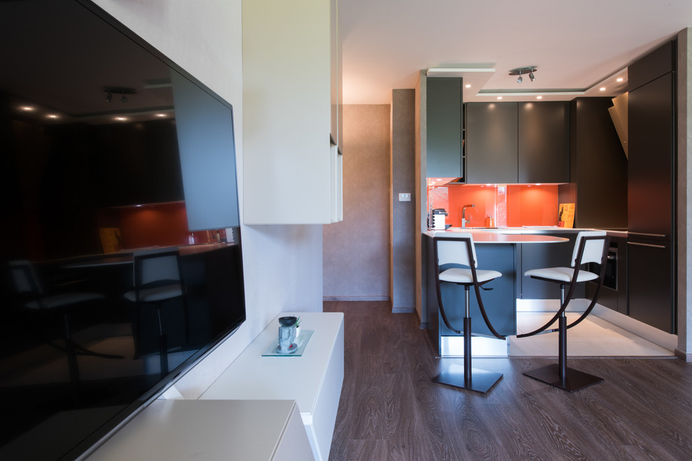 Mid-sized tropical u-shaped open plan kitchen in Paris with an integrated sink, beaded inset cabinets, brown cabinets, solid surface benchtops, orange splashback, glass tile splashback, panelled appliances, ceramic floors and a peninsula.
