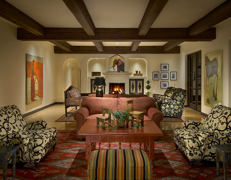 Photo of a large mediterranean formal enclosed living room in Phoenix with beige walls, a standard fireplace, a plaster fireplace surround, medium hardwood floors and no tv.