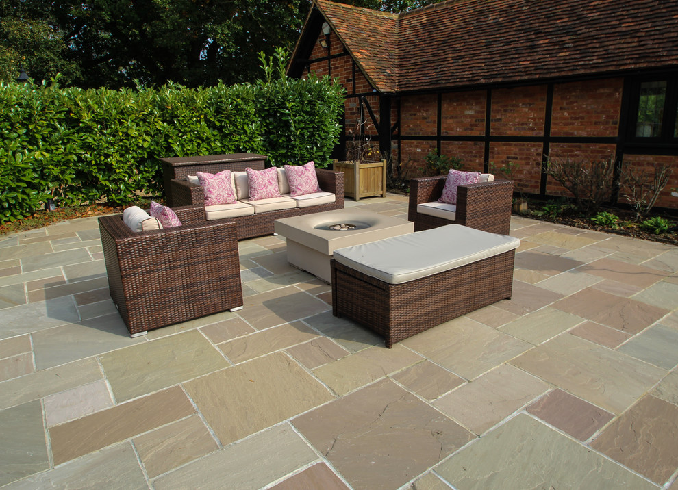 Mid-sized traditional backyard patio in Berkshire with natural stone pavers.