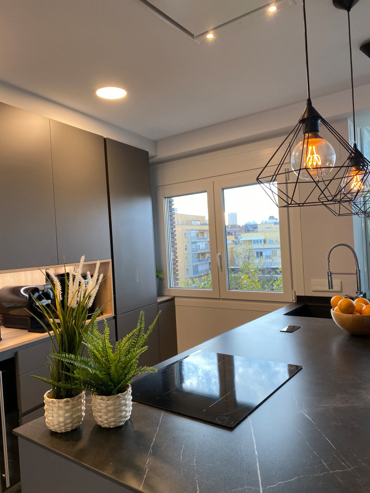 Foto de cocina lineal contemporánea de tamaño medio abierta con encimera de cuarzo compacto, una isla, encimeras negras, fregadero bajoencimera, electrodomésticos negros, armarios tipo vitrina, puertas de armario negras, suelo laminado y suelo marrón