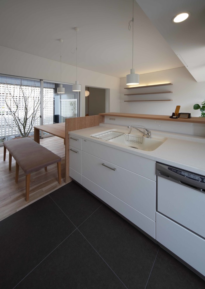Photo of a small scandinavian single-wall open plan kitchen in Other with white cabinets, solid surface benchtops, ceramic floors, with island, brown floor and white benchtop.
