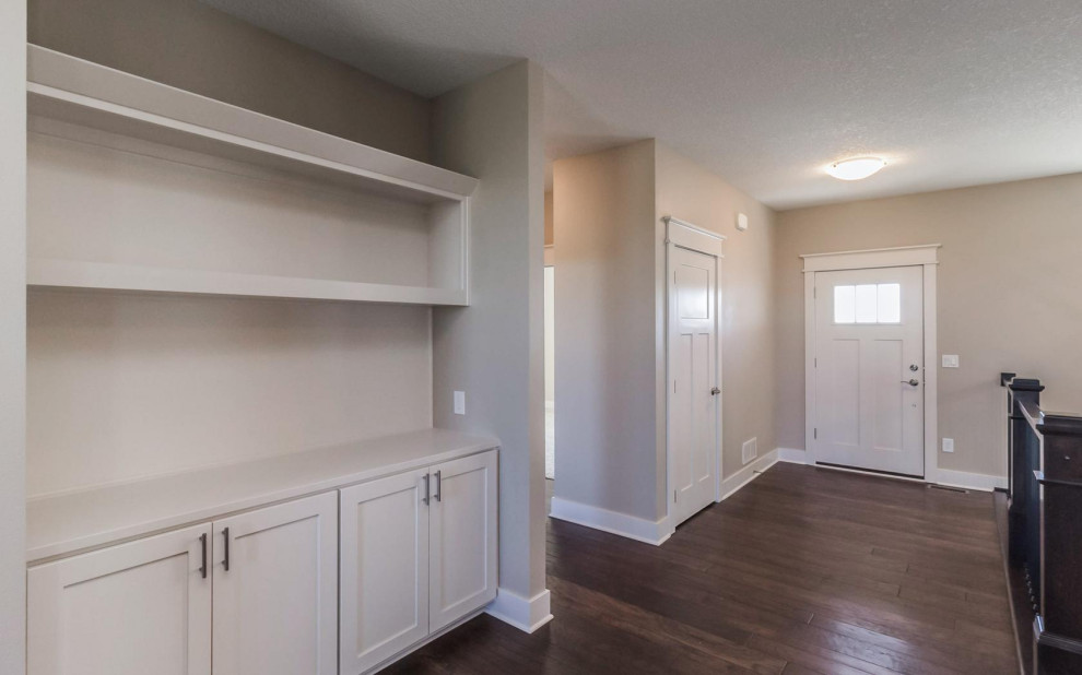 Example of a transitional medium tone wood floor and brown floor front door design with beige walls and a red front door