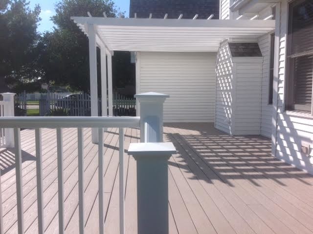 Photo of a mid-sized transitional backyard deck in Chicago with a pergola.