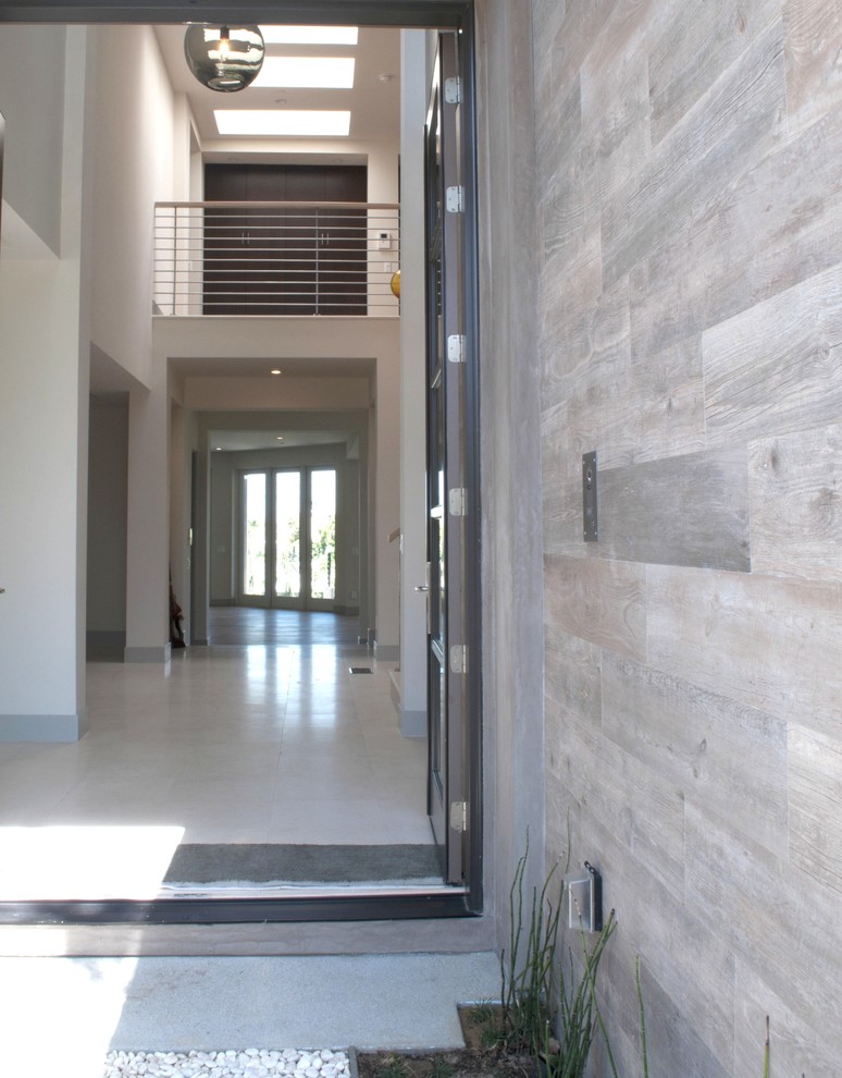 Large contemporary front door in Los Angeles with brown walls, limestone floors, a double front door and a metal front door.