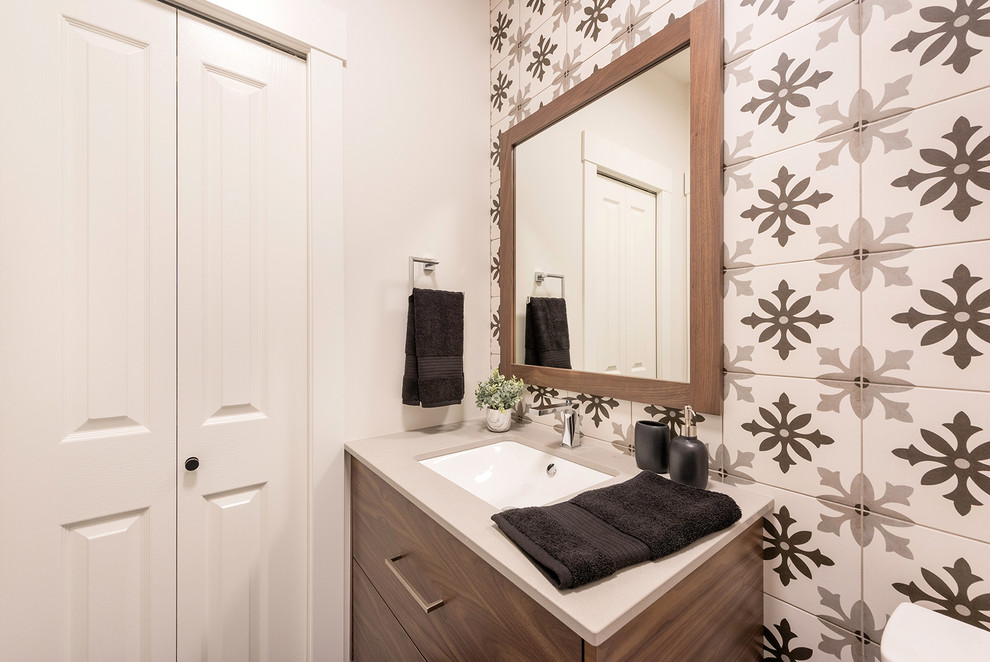 Design ideas for a small transitional powder room in Vancouver with flat-panel cabinets, dark wood cabinets, a one-piece toilet, multi-coloured tile, ceramic tile, white walls, vinyl floors, an undermount sink, engineered quartz benchtops, beige floor and grey benchtops.