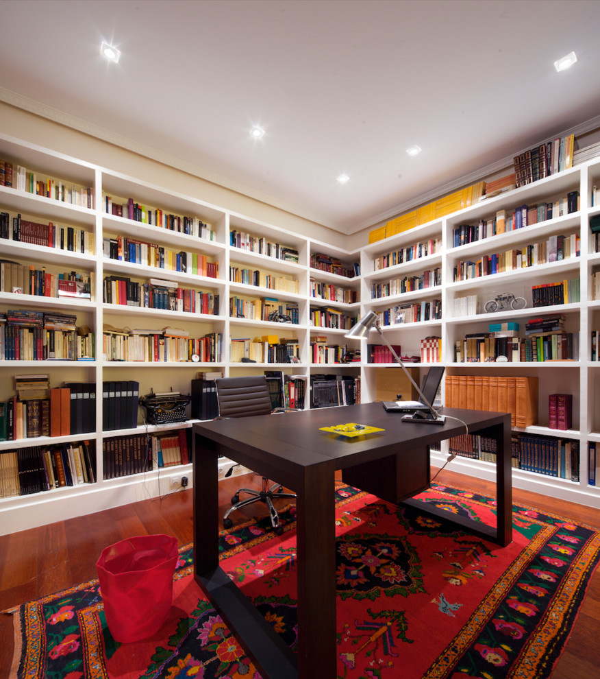 This is an example of a mid-sized transitional study room in Madrid with white walls, dark hardwood floors, no fireplace and a freestanding desk.