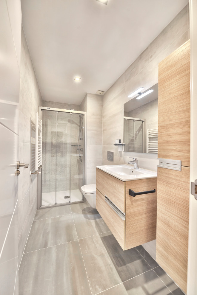 Mid-sized scandinavian 3/4 bathroom in Madrid with flat-panel cabinets, white cabinets, a curbless shower, gray tile, ceramic tile, grey walls, porcelain floors, grey floor, a sliding shower screen, an enclosed toilet and a single vanity.