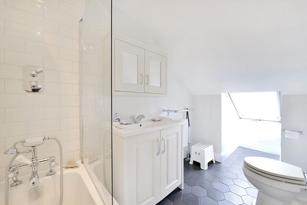 Inspiration for a mid-sized transitional master bathroom in London with flat-panel cabinets, white cabinets, a drop-in tub, an open shower, a one-piece toilet, white tile, cement tile, white walls, light hardwood floors, a drop-in sink, wood benchtops, black floor and an open shower.