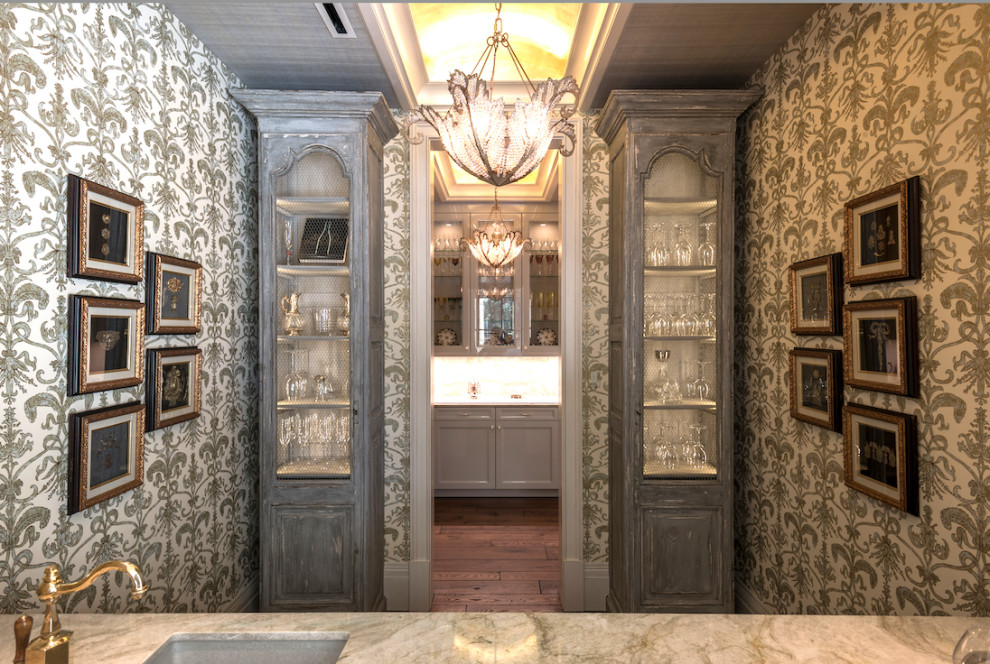 Inspiration for a large traditional wet bar in Houston with an undermount sink, recessed-panel cabinets, grey cabinets, marble benchtops, green splashback, marble splashback, dark hardwood floors, brown floor and green benchtop.