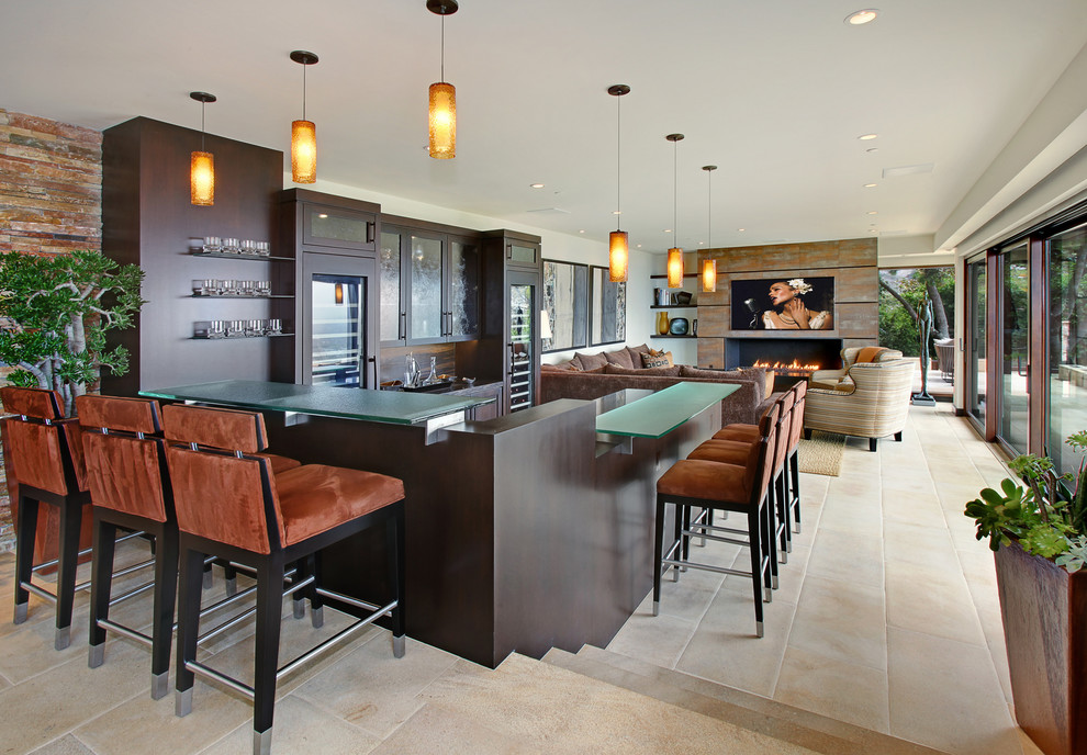 Design ideas for an expansive contemporary u-shaped seated home bar in Orange County with dark wood cabinets, glass benchtops, shaker cabinets, brown splashback, timber splashback, ceramic floors and beige floor.