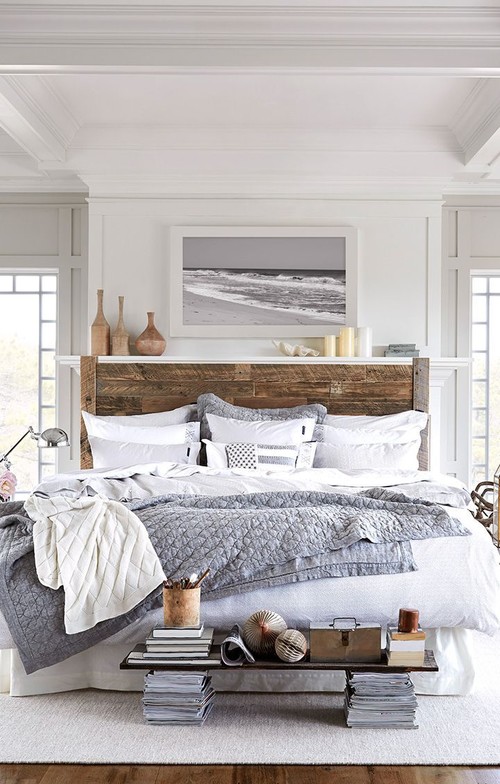 modern beachy bedroom with shiplap headboard and white bedding with a grey throw blanket and a black and white ocean picture above bed