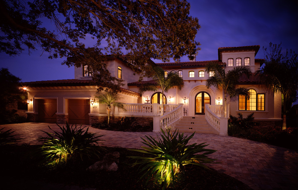 Inspiration for a large mediterranean two-storey stucco beige exterior in Tampa with a hip roof.