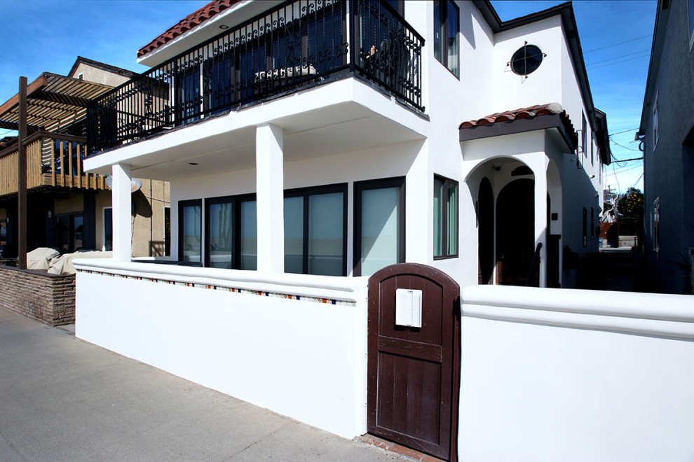 Ispirazione per la facciata di una casa bifamiliare grande bianca mediterranea a due piani con rivestimento in stucco, tetto piano, copertura a scandole e tetto rosso