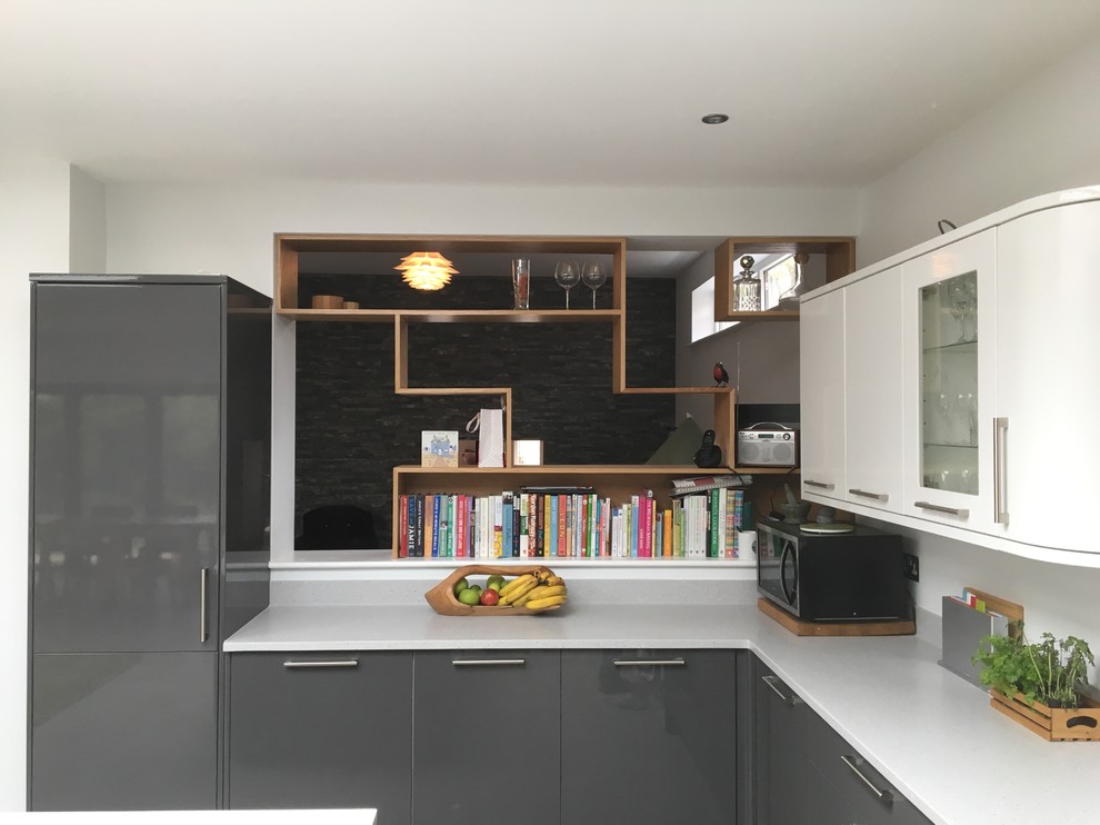 Photo of a large modern l-shaped open plan kitchen in Other with an undermount sink, flat-panel cabinets, grey cabinets, quartz benchtops, green splashback, glass sheet splashback, panelled appliances, linoleum floors, with island and grey floor.