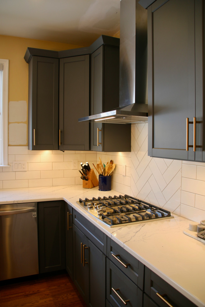 Inredning av ett modernt mellanstort vit vitt kök, med en undermonterad diskho, skåp i shakerstil, blå skåp, bänkskiva i kvarts, vitt stänkskydd, stänkskydd i tunnelbanekakel, rostfria vitvaror, mellanmörkt trägolv, en köksö och brunt golv