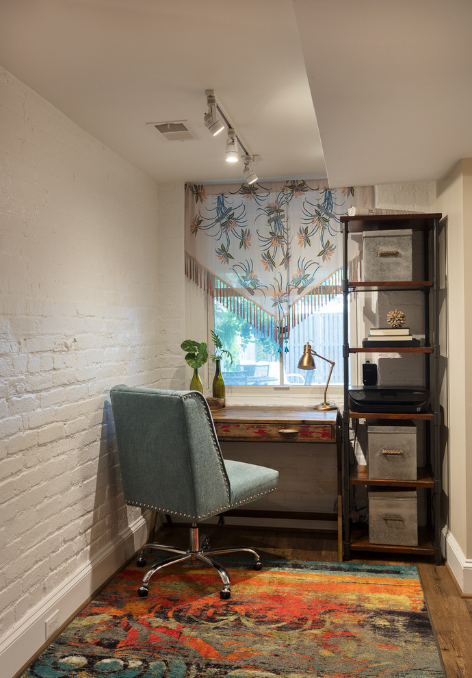 Small eclectic study room in DC Metro with white walls, vinyl floors, no fireplace, a freestanding desk and brown floor.