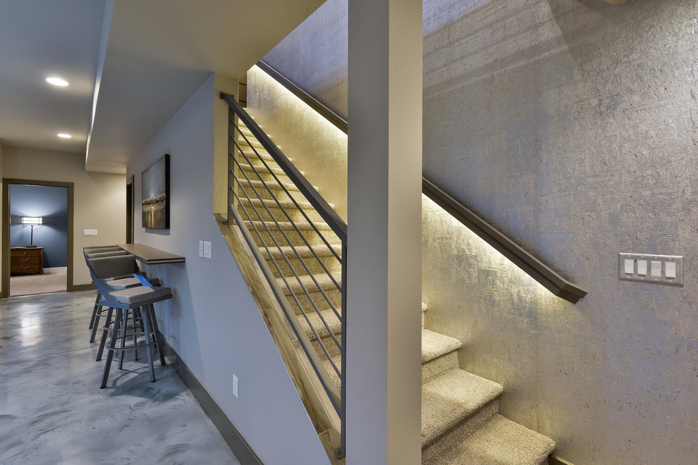 This is an example of a mid-sized contemporary carpeted straight staircase in Denver with carpet risers and metal railing.