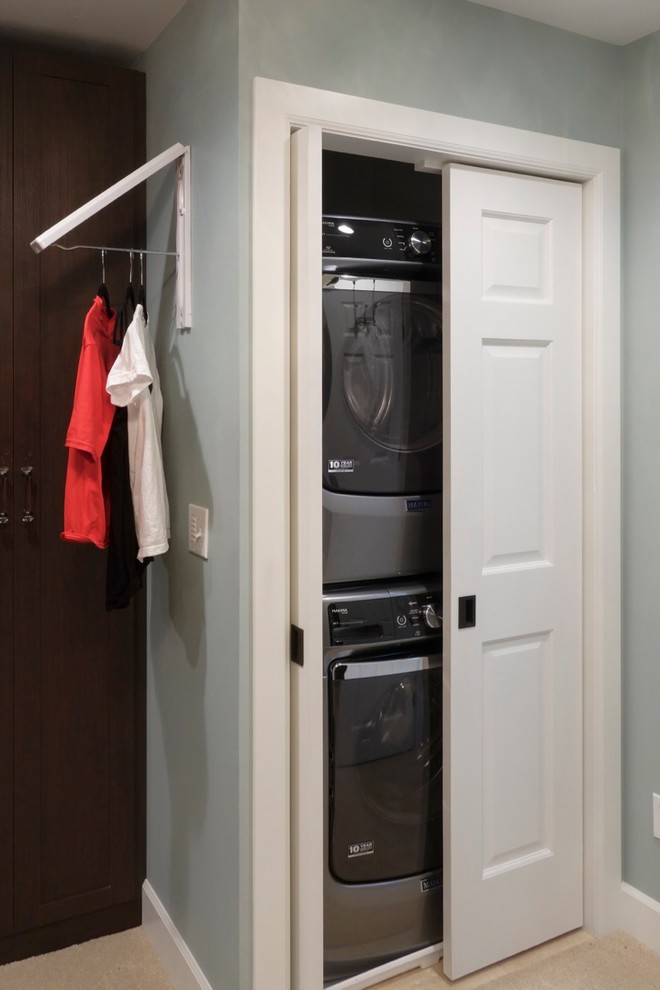 Photo of a large transitional gender-neutral walk-in wardrobe in Seattle with shaker cabinets, dark wood cabinets and carpet.