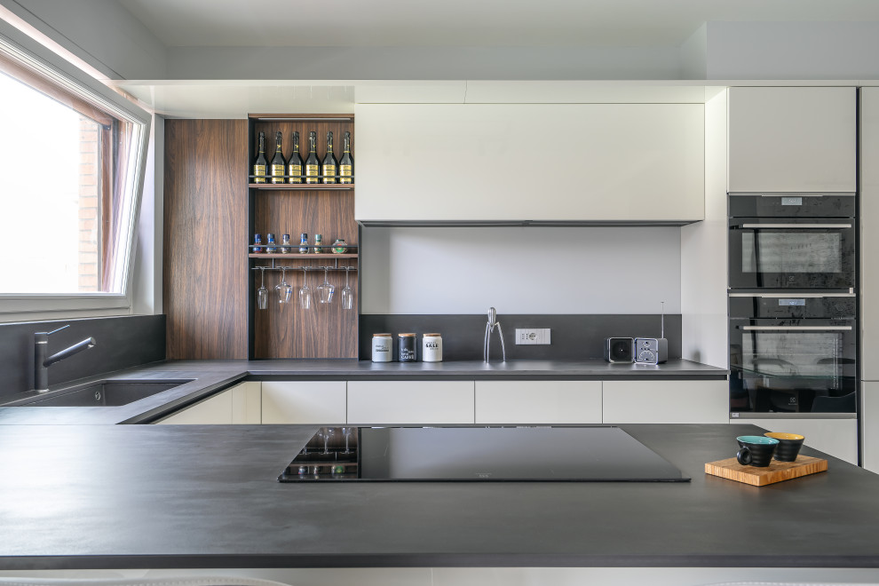 This is an example of a scandi u-shaped open plan kitchen in Rome with a breakfast bar.