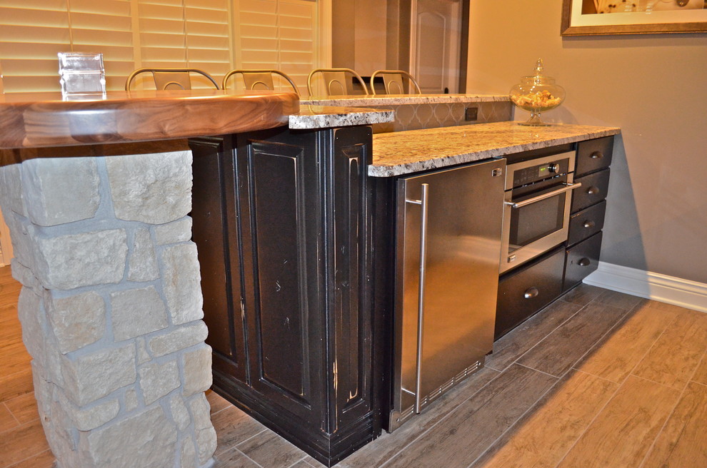 Inspiration for a rustic ceramic tile home design remodel in Omaha with an undermount sink, black cabinets, granite countertops and glass tile backsplash