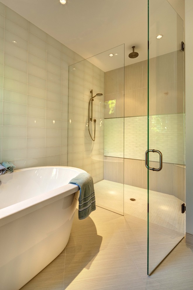 Tropical bathroom in Tampa with a curbless shower, a freestanding tub, white tile and glass tile.