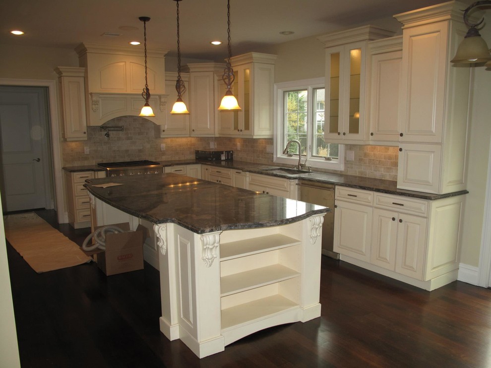 Eat-in kitchen - transitional l-shaped dark wood floor eat-in kitchen idea in New York with a double-bowl sink, raised-panel cabinets, white cabinets, granite countertops, beige backsplash, stone tile backsplash, stainless steel appliances and an island