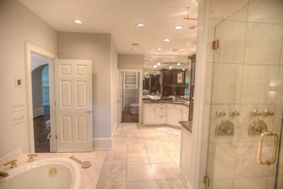 Design ideas for an expansive mediterranean master bathroom in Atlanta with an undermount sink, flat-panel cabinets, light wood cabinets, granite benchtops, an undermount tub, a corner shower, a two-piece toilet, beige tile, stone tile, grey walls and travertine floors.