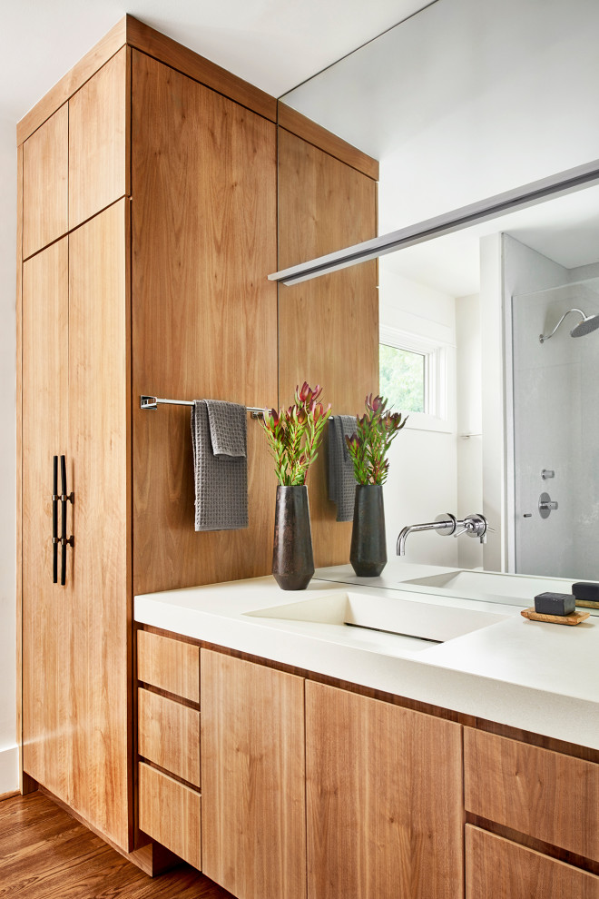 Example of a small trendy master medium tone wood floor, brown floor and single-sink bathroom design in Atlanta with flat-panel cabinets, light wood cabinets, white walls, an integrated sink, concrete countertops, white countertops and a built-in vanity