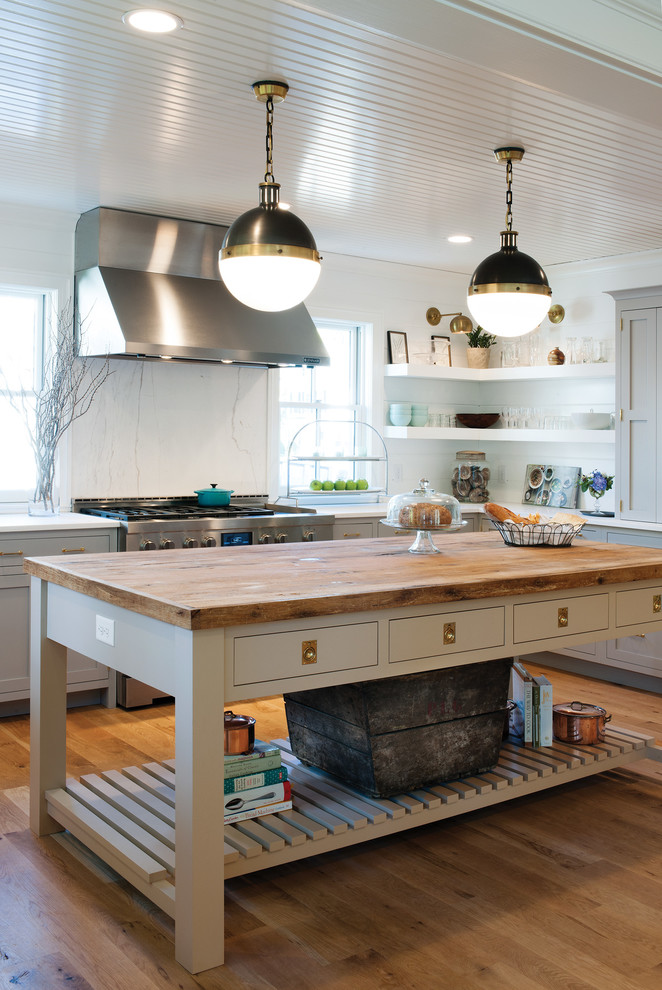 This is an example of a country u-shaped kitchen in Boston with shaker cabinets, grey cabinets, white splashback, stainless steel appliances, medium hardwood floors and with island.