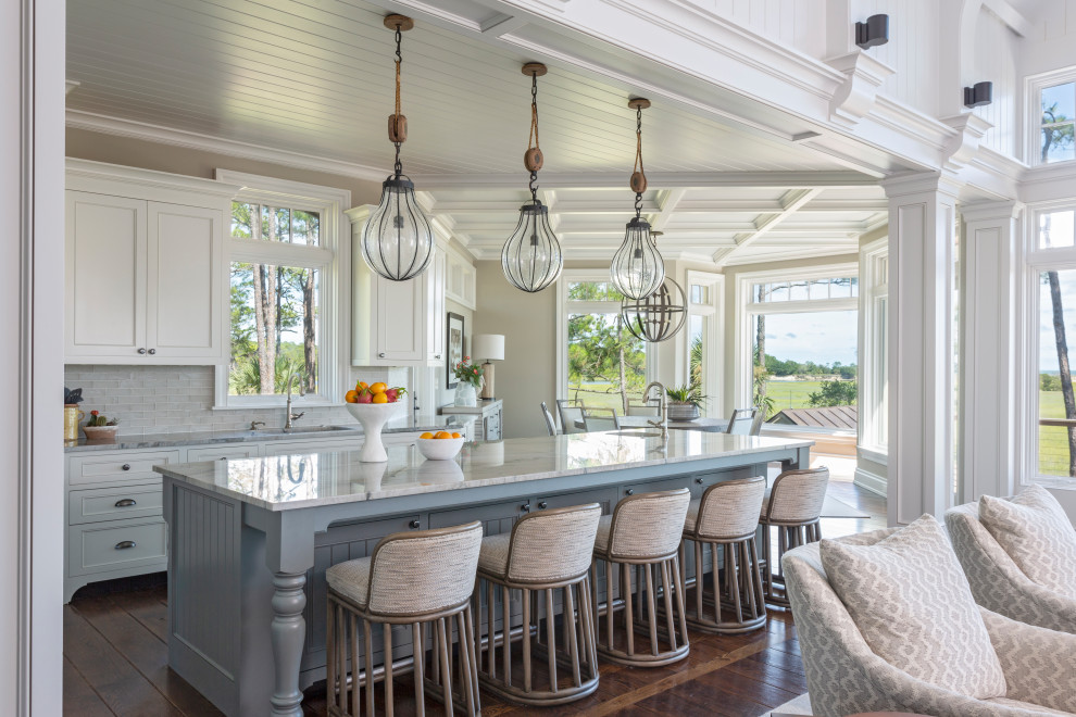 Design ideas for a beach style l-shaped open plan kitchen in Charleston with an undermount sink, recessed-panel cabinets, white cabinets, grey splashback, dark hardwood floors, with island, brown floor, grey benchtop and timber.