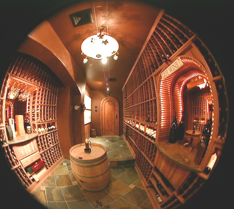 This is an example of a large transitional wine cellar in San Francisco with display racks and slate floors.