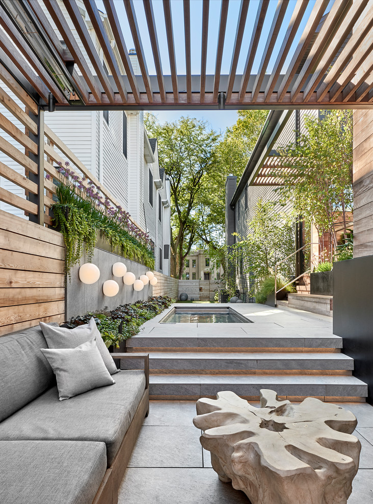 Foto di un patio o portico contemporaneo dietro casa con piastrelle