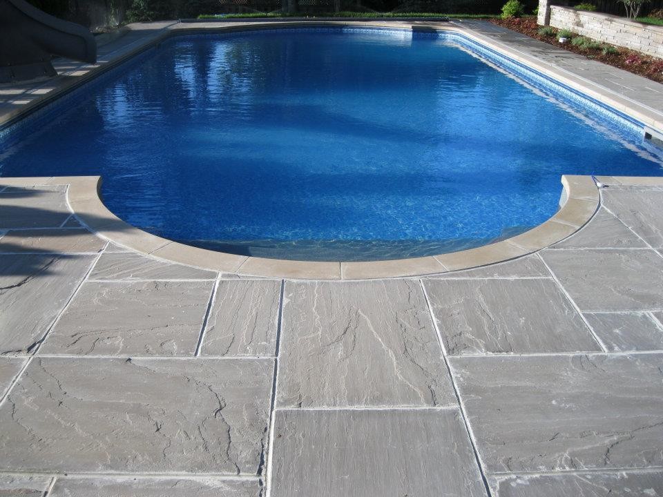 Large backyard stone pool photo in Toronto