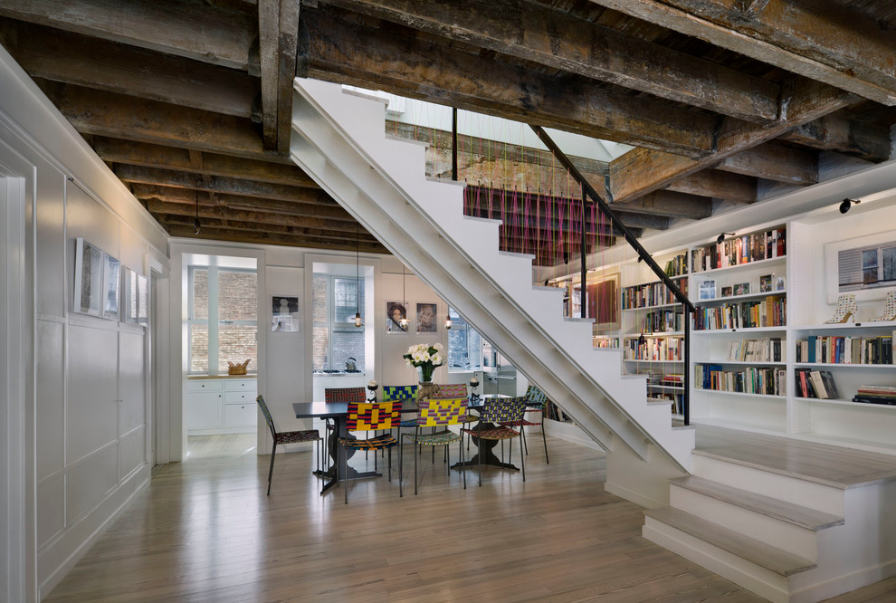 This is an example of an industrial wood l-shaped staircase in New York with painted wood risers.