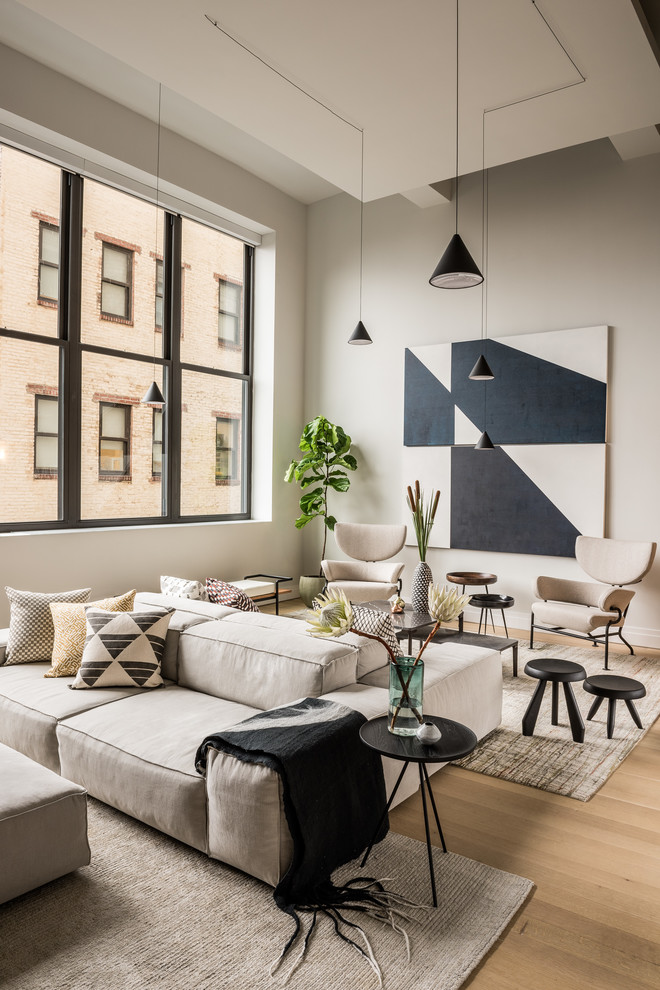 Inspiration for a mid-sized contemporary formal loft-style living room in New York with grey walls, light hardwood floors, no fireplace, no tv and beige floor.