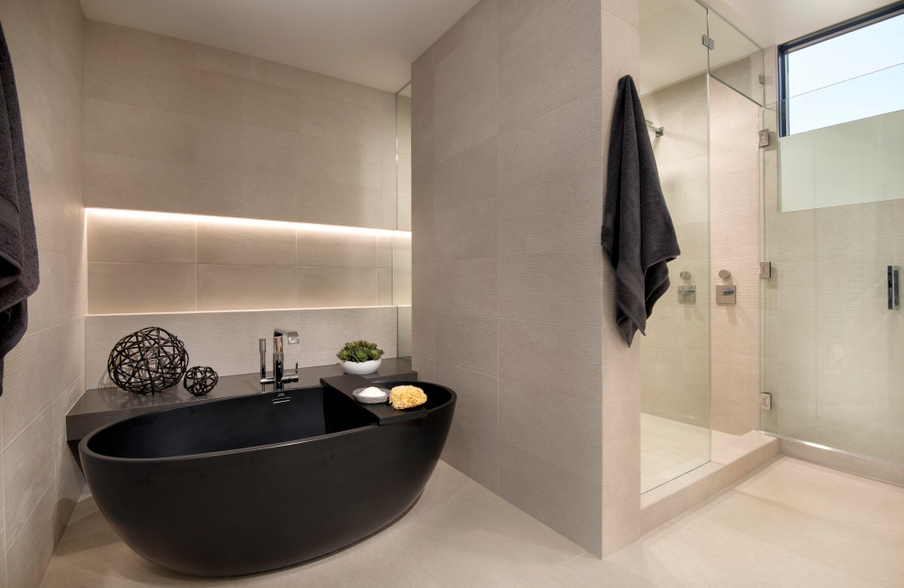 Design ideas for a large modern ensuite wet room bathroom in Phoenix with a freestanding bath, a two-piece toilet, beige tiles, stone tiles, beige walls, beige floors, a hinged door and a shower bench.