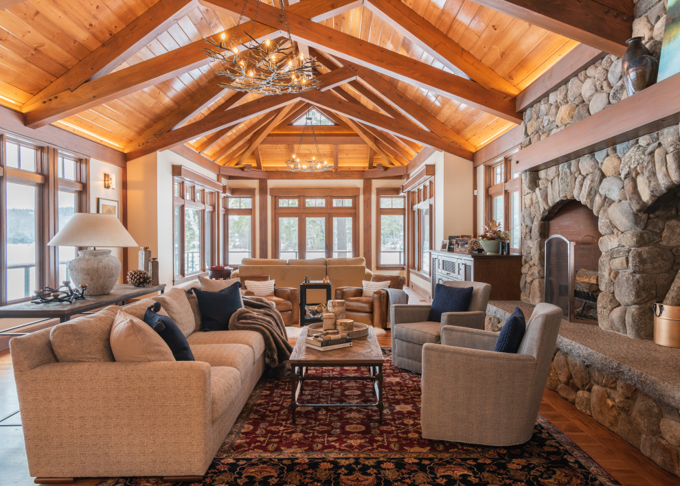 Inspiration for a rustic formal and open concept medium tone wood floor, brown floor and exposed beam living room remodel in Other with white walls and a stone fireplace