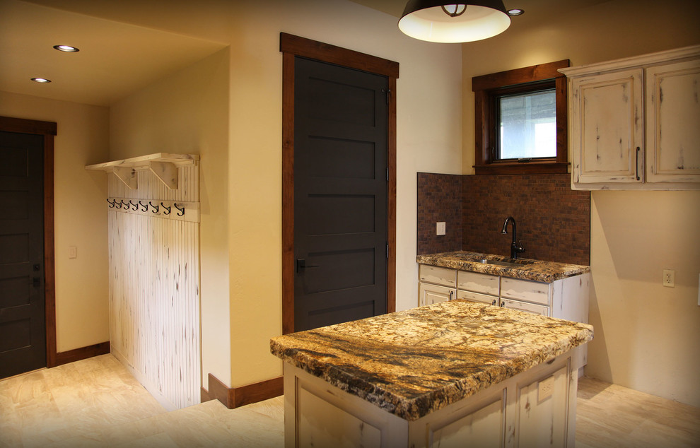 Laundry room - rustic laundry room idea with an utility sink, white cabinets, granite countertops and beige walls