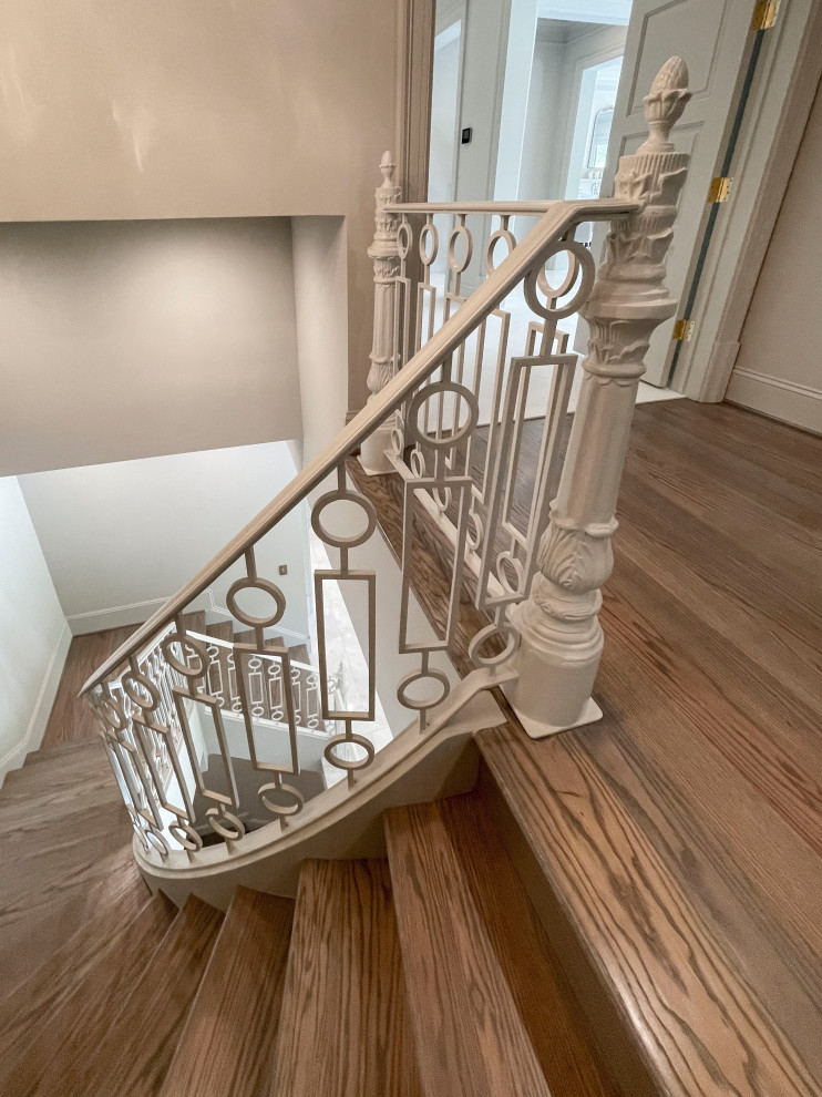 Photo of an expansive classic wood floating metal railing staircase in DC Metro with wood risers and panelled walls.