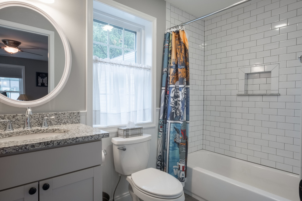 Small country kids bathroom in Other with shaker cabinets, white cabinets, a drop-in tub, a shower/bathtub combo, white tile, porcelain tile, grey walls, a console sink, granite benchtops, a shower curtain and multi-coloured benchtops.