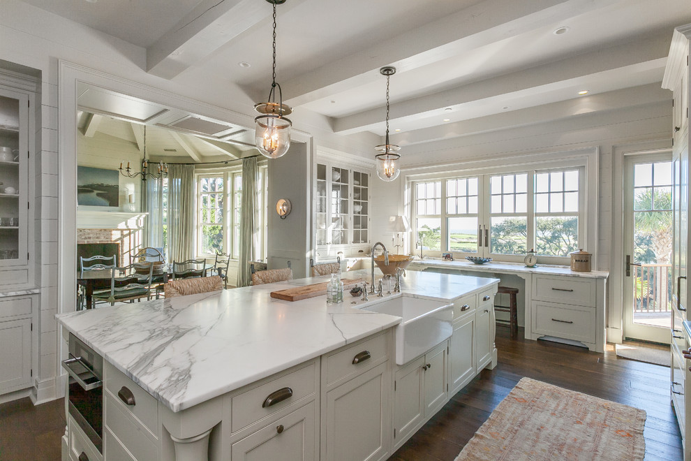 This is an example of a large beach style kitchen in Charleston with shaker cabinets, white cabinets, marble benchtops, with island, a farmhouse sink and medium hardwood floors.