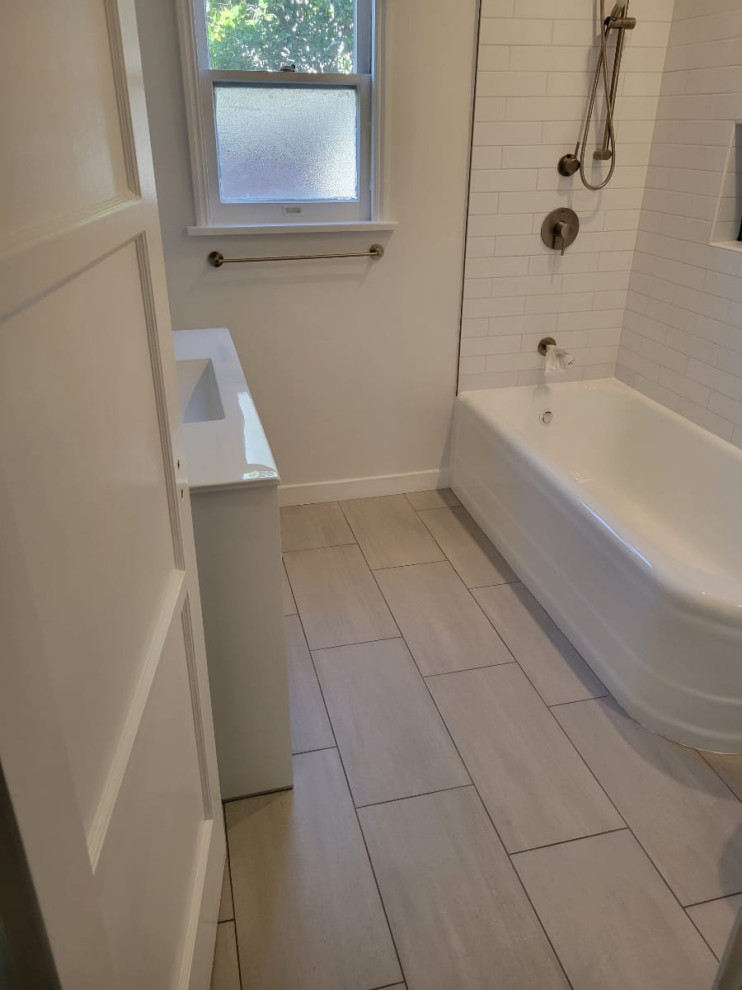 Design ideas for a mid-sized traditional 3/4 bathroom in Los Angeles with flat-panel cabinets, white cabinets, a corner tub, a shower/bathtub combo, a one-piece toilet, white tile, porcelain tile, white walls, ceramic floors, an integrated sink, tile benchtops, grey floor, a shower curtain, white benchtops, a single vanity and a freestanding vanity.