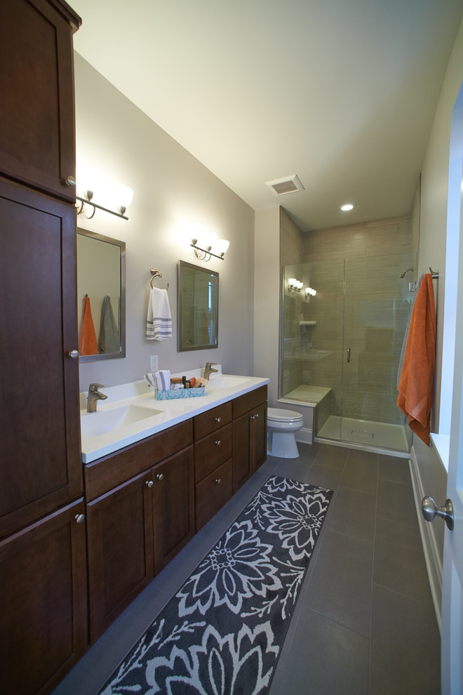 Design ideas for a mid-sized contemporary master bathroom in St Louis with an integrated sink, shaker cabinets, dark wood cabinets, solid surface benchtops, an alcove shower, a two-piece toilet, beige tile, ceramic tile, white walls and ceramic floors.