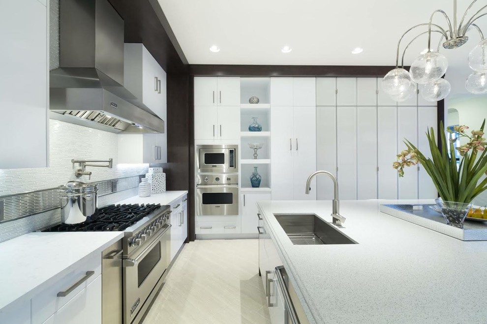 This is an example of a mid-sized contemporary u-shaped separate kitchen in Miami with an undermount sink, flat-panel cabinets, white cabinets, terrazzo benchtops, stainless steel appliances and with island.