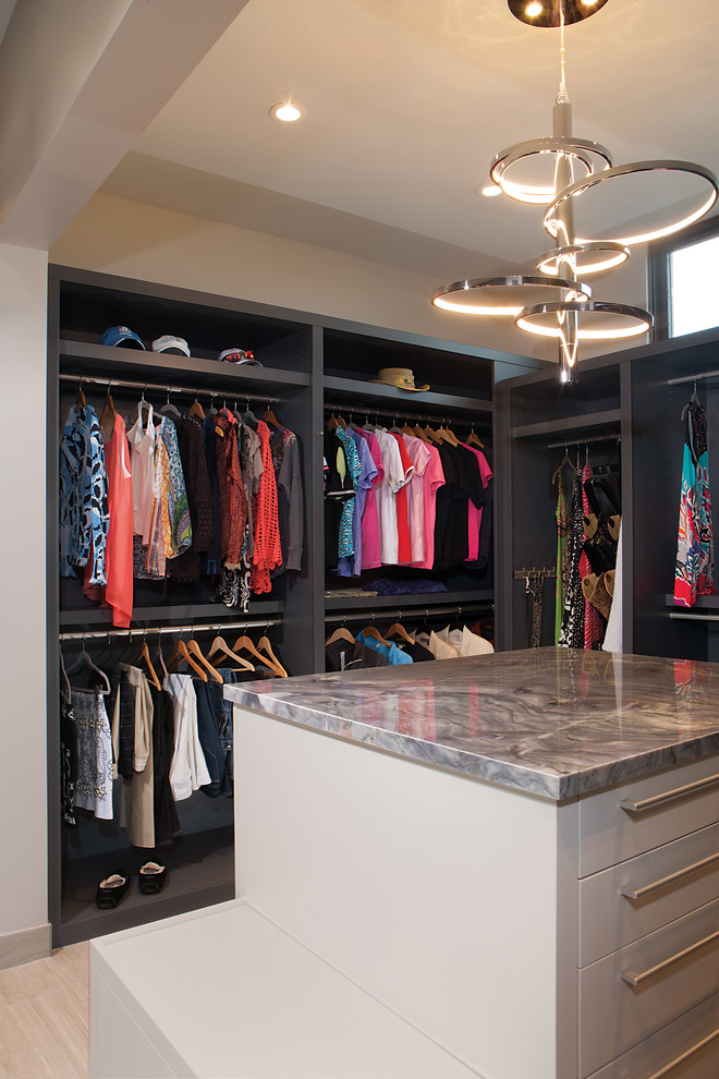 Photo of a mid-sized contemporary gender-neutral walk-in wardrobe in Phoenix with flat-panel cabinets, grey cabinets, porcelain floors and beige floor.