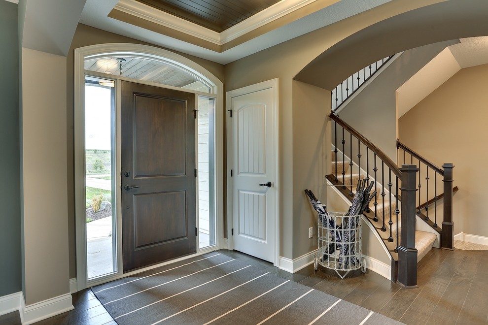 Inspiration for a large transitional foyer in Minneapolis with beige walls, dark hardwood floors and a dark wood front door.