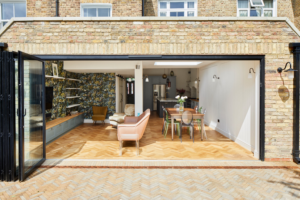 Modern open-plan kitchen extension with glass doors and herringbone flooring.